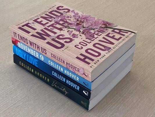 Stack of books by Colleen Hoover on a wooden surface